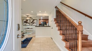 Un interior moderno con una escalera de madera, una zona de cocina y un comedor.