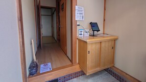 Un pasillo con una recepción de madera, un cartel que indica la hora de salida y un suelo de baldosas.