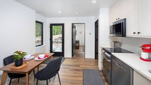 Une cuisine moderne avec un coin repas, comprenant une table en bois, des chaises et une plante en pot.