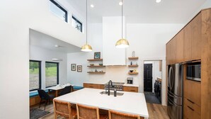 Une cuisine moderne dotée d’un îlot central, de meubles en bois et d’appareils électroménagers en acier inoxydable.