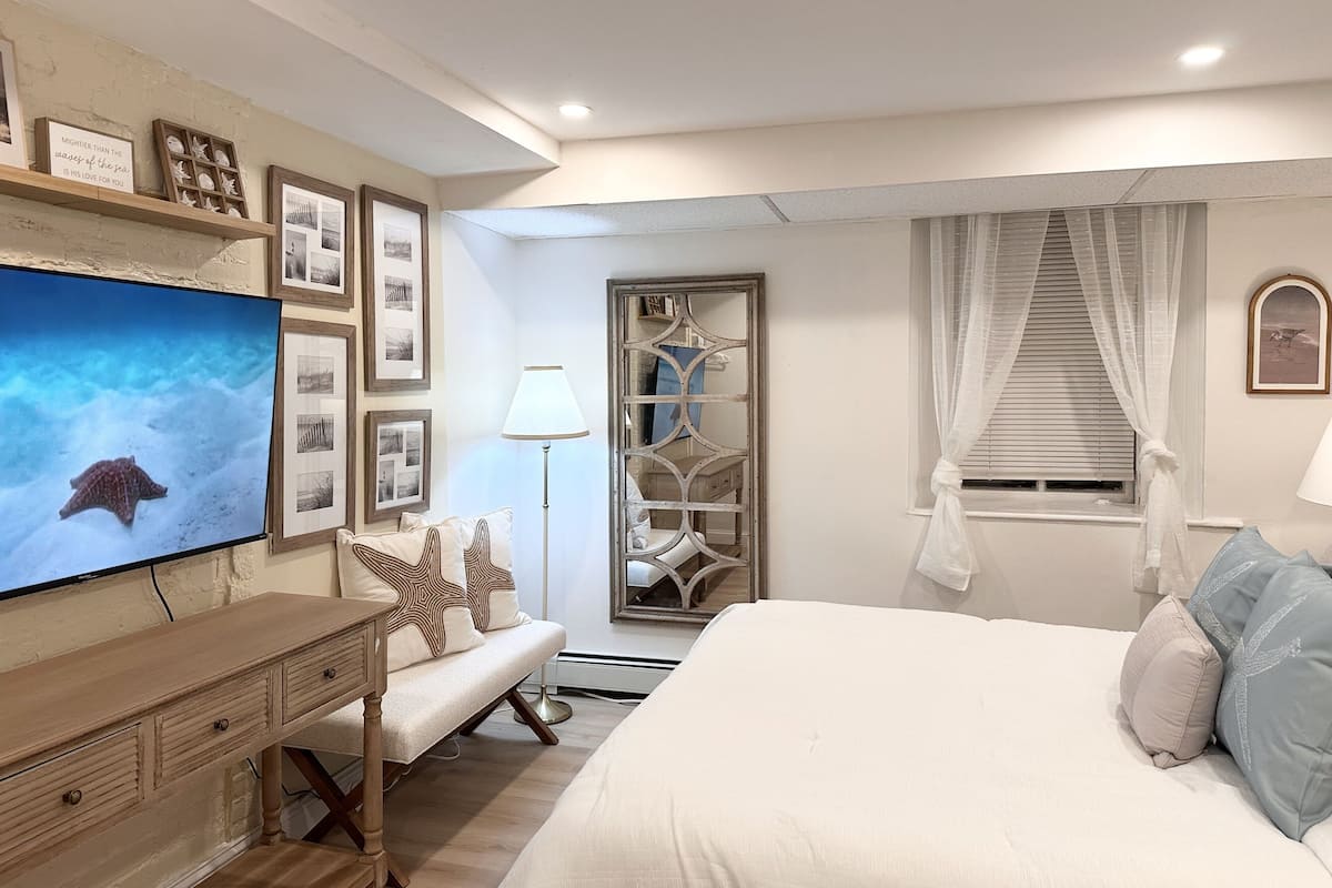 A bedroom with a bed, a dresser, a TV, and a wardrobe.