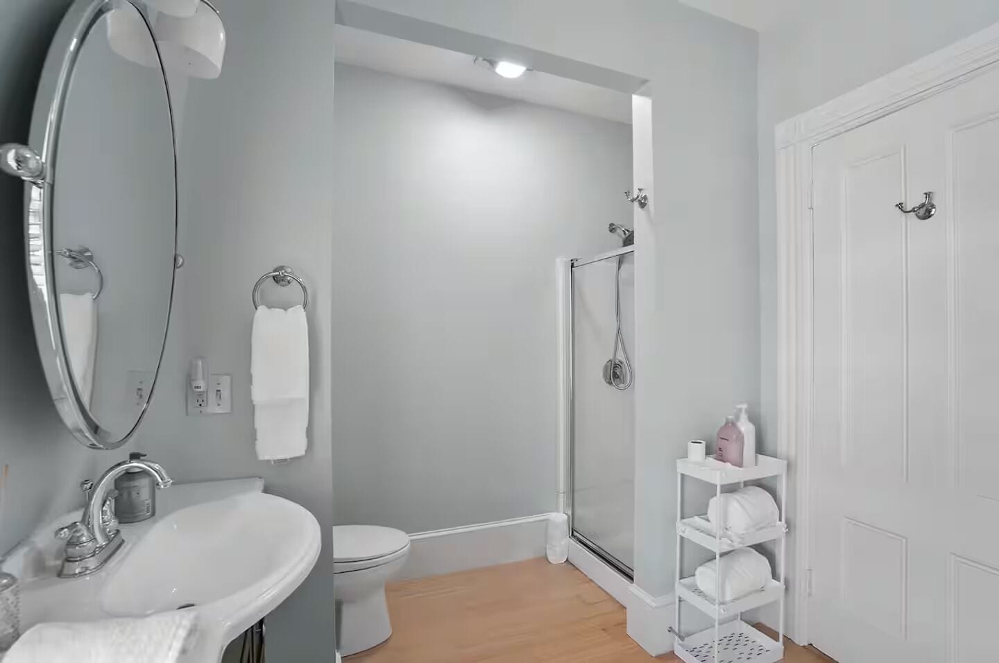 Une salle de bain avec un lavabo, des toilettes, une douche et une porte blanche.