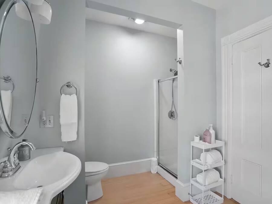 Une salle de bain avec un lavabo, des toilettes, une douche et une porte blanche.