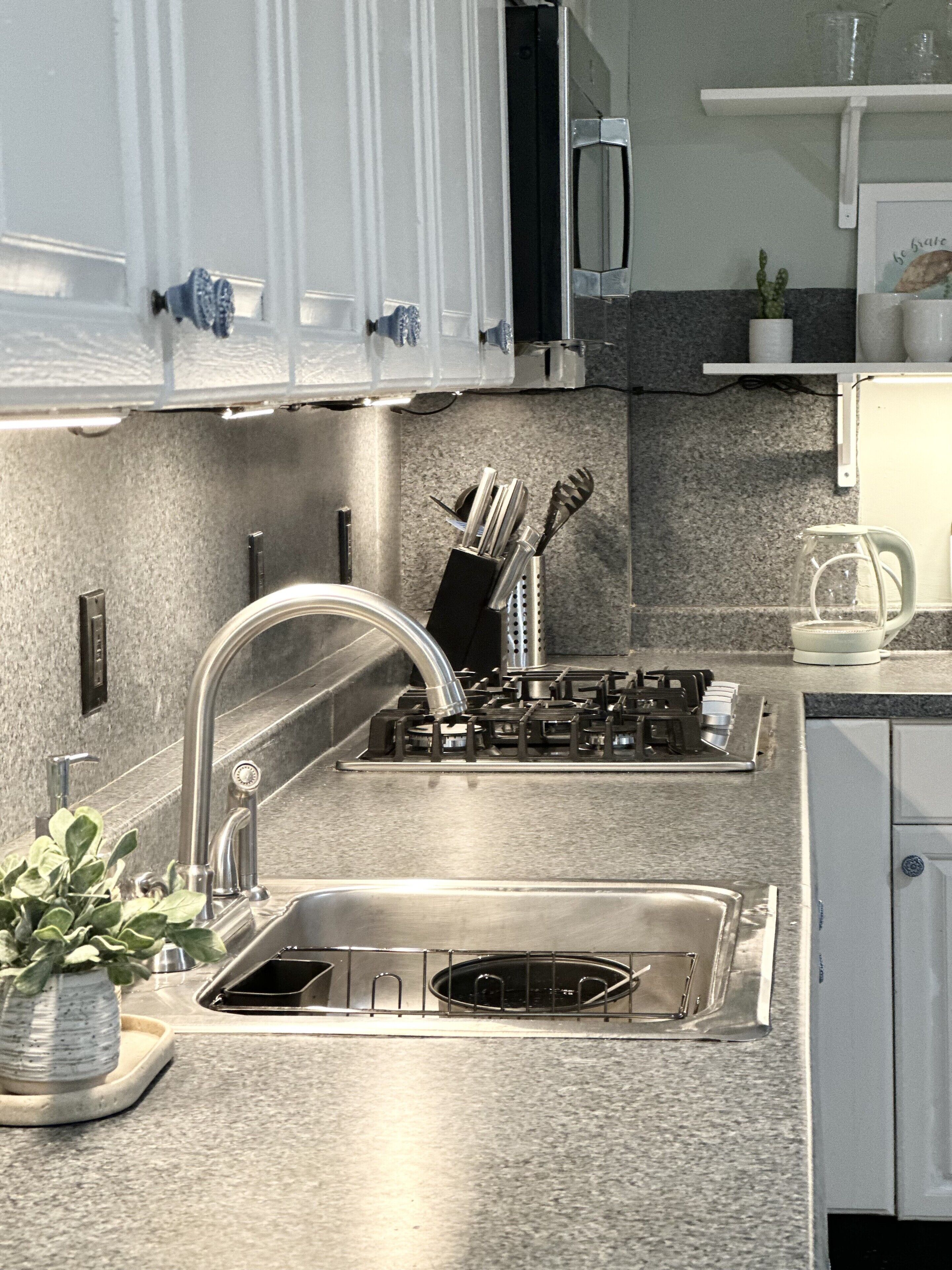 A modern kitchen with stainless steel appliances, a sink, and a countertop.