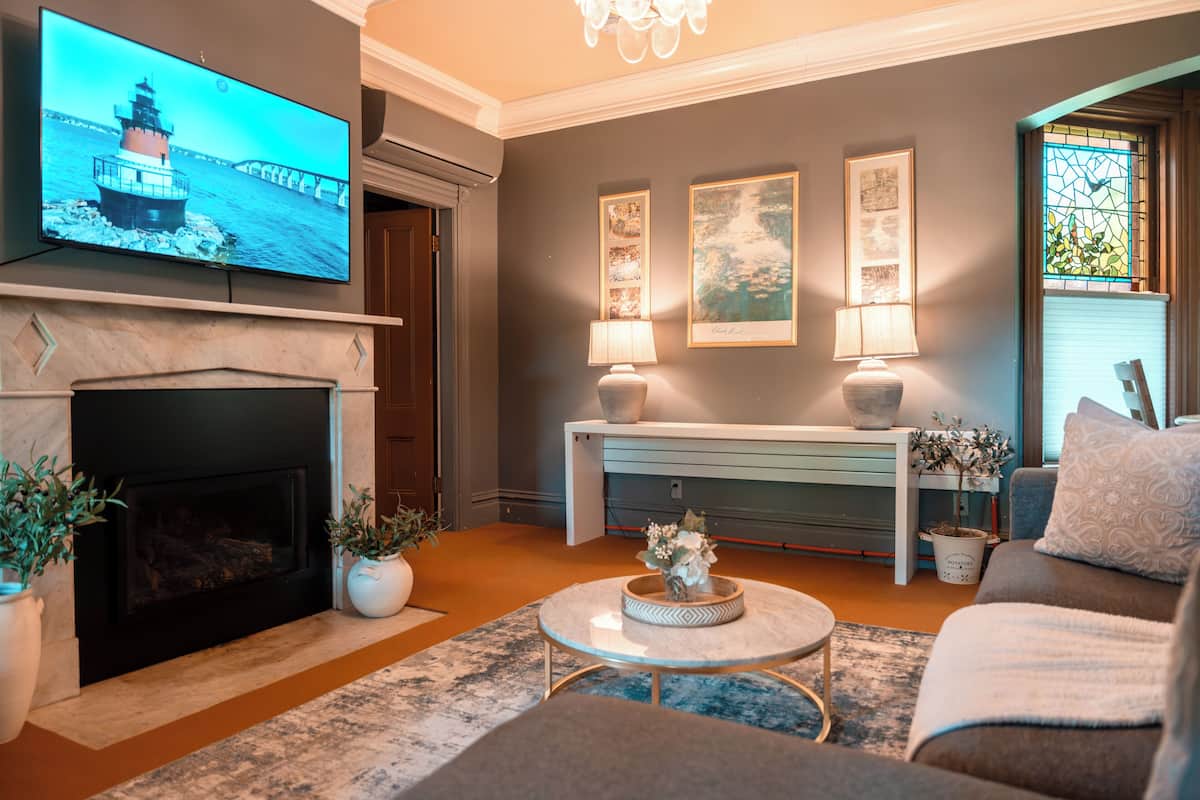 Una sala de estar con chimenea, televisor y un área de estar acogedora.
