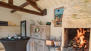 Un interno rustico con camino in pietra, mobili in legno e un tavolo con tazze.