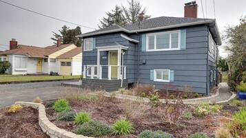A two-story house with a front porch and a landscaped garden.