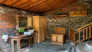 A rustic bathroom with a wooden vanity, a sink, and a mirror. - Sirya Farm House (Tabanan)