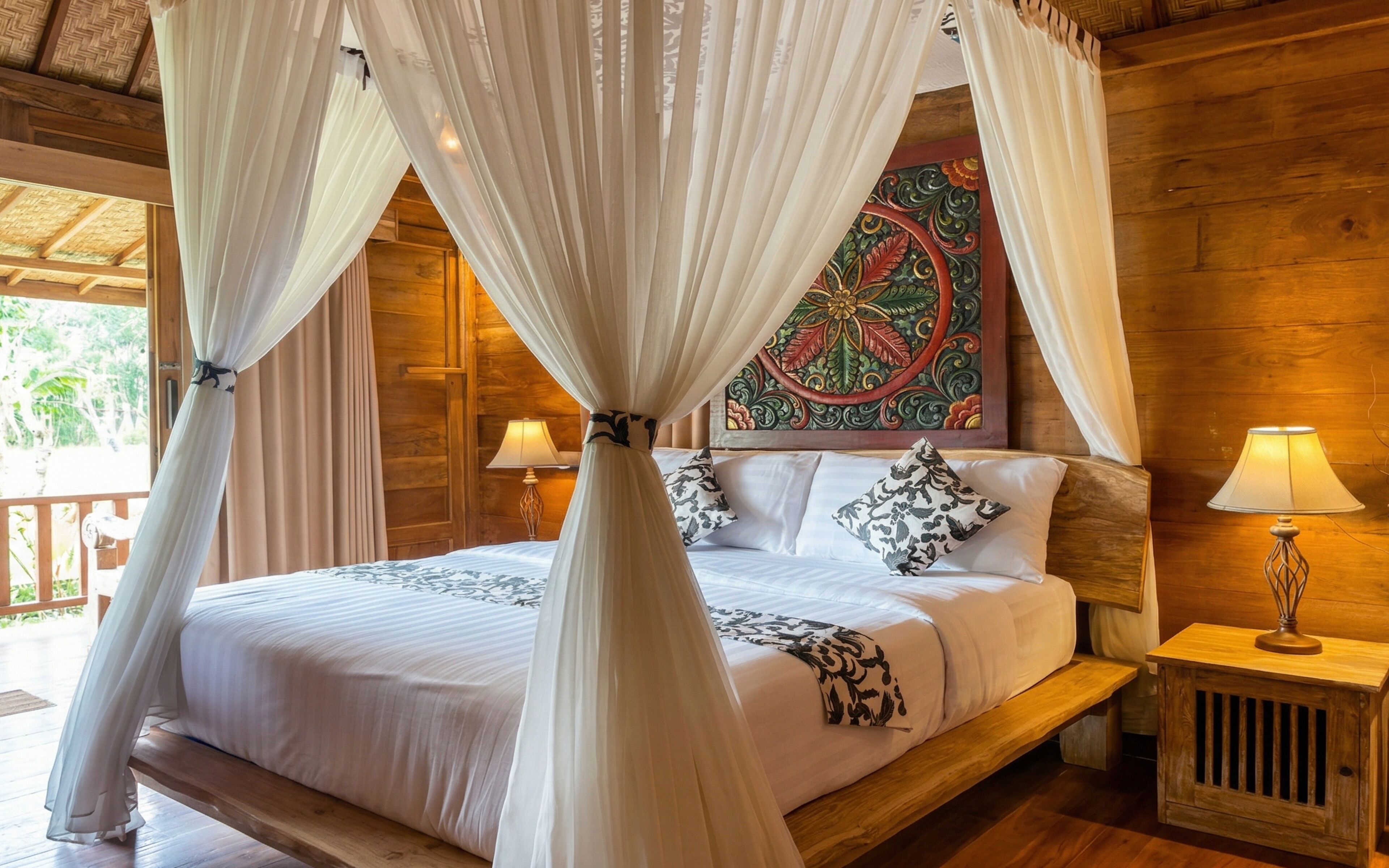 A bed with a canopy, a nightstand with a lamp, and a decorative painting on the wall.
