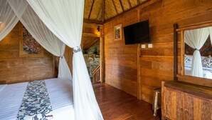 A wooden cabin room with a bed, a TV, and a mirror. - Sirya Farm House (Tabanan)