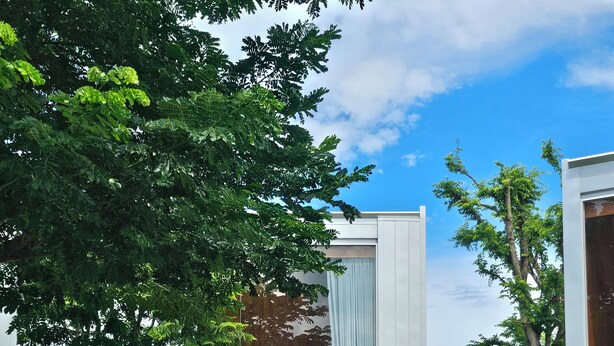 Een modern huis met een glazen deur die leidt naar een slaapkamer.