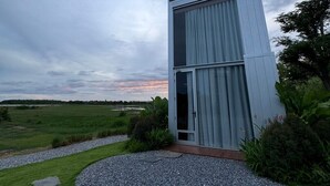 Een modern gebouw met een glazen deur en een grindpad dat er naartoe leidt.
