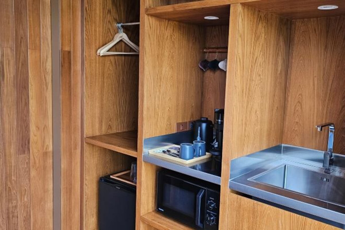 A compact kitchen with a built-in sink, a coffee maker, and a microwave.