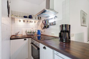 Een koelkast, een oven, een kookplaat, een koffiezetapparaat/waterkoker