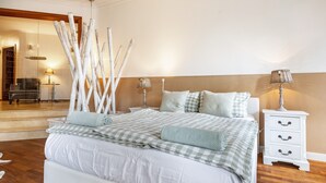 Un dormitorio con una cama grande, mesitas de noche y un espejo.