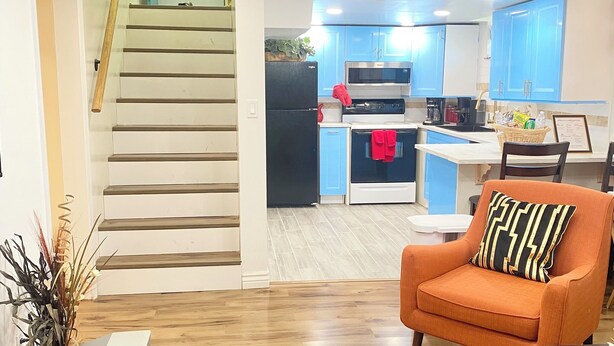 A modern kitchen with blue cabinets, a black refrigerator, and a microwave. - Enchanting 2-bedroom house across ISU in Pocatello (Pocatello)
