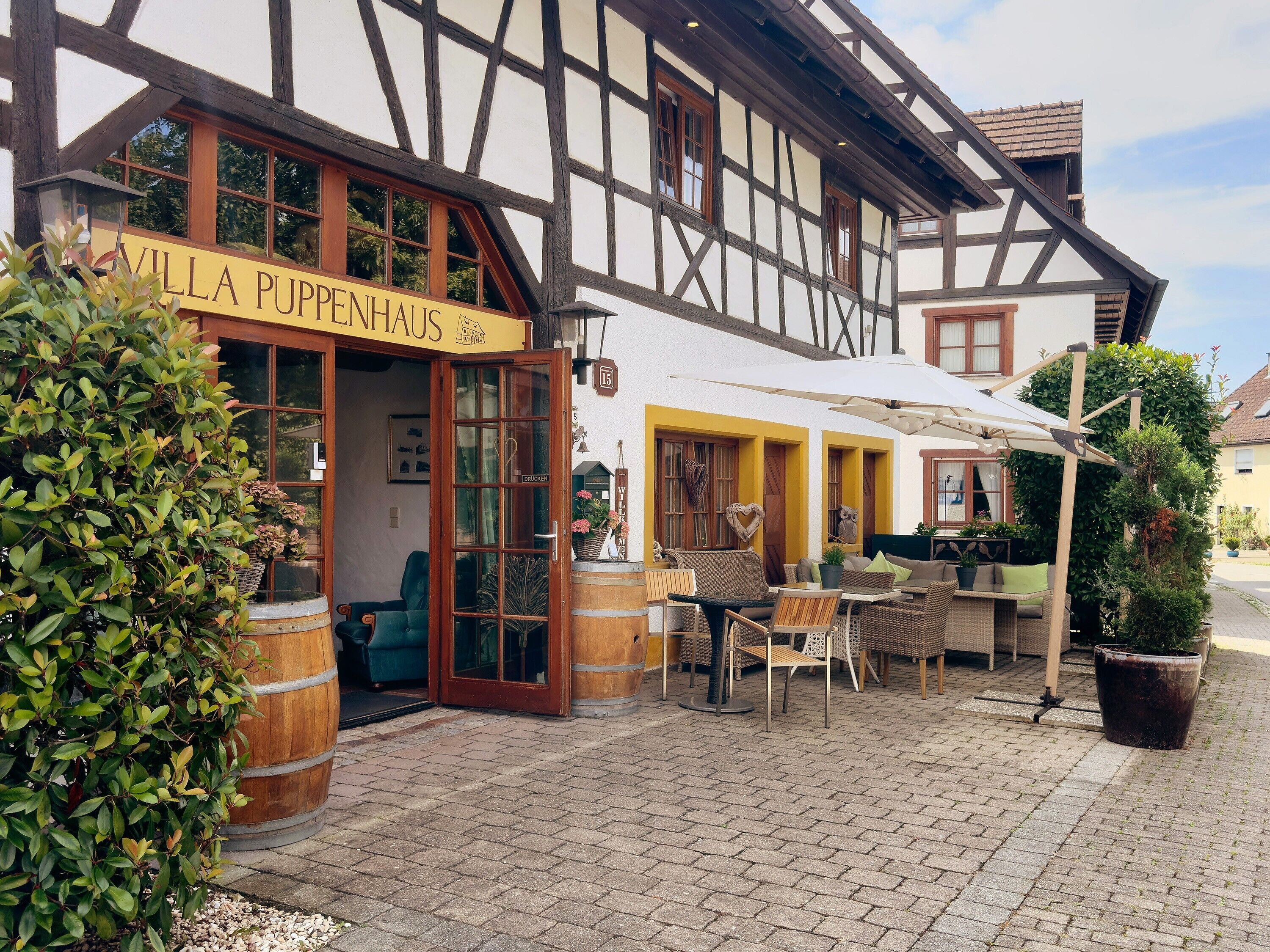 Ein traditionelles Fachwerkhäuschen mit einem Schild, auf dem 'Villa Puppenhaus' steht.