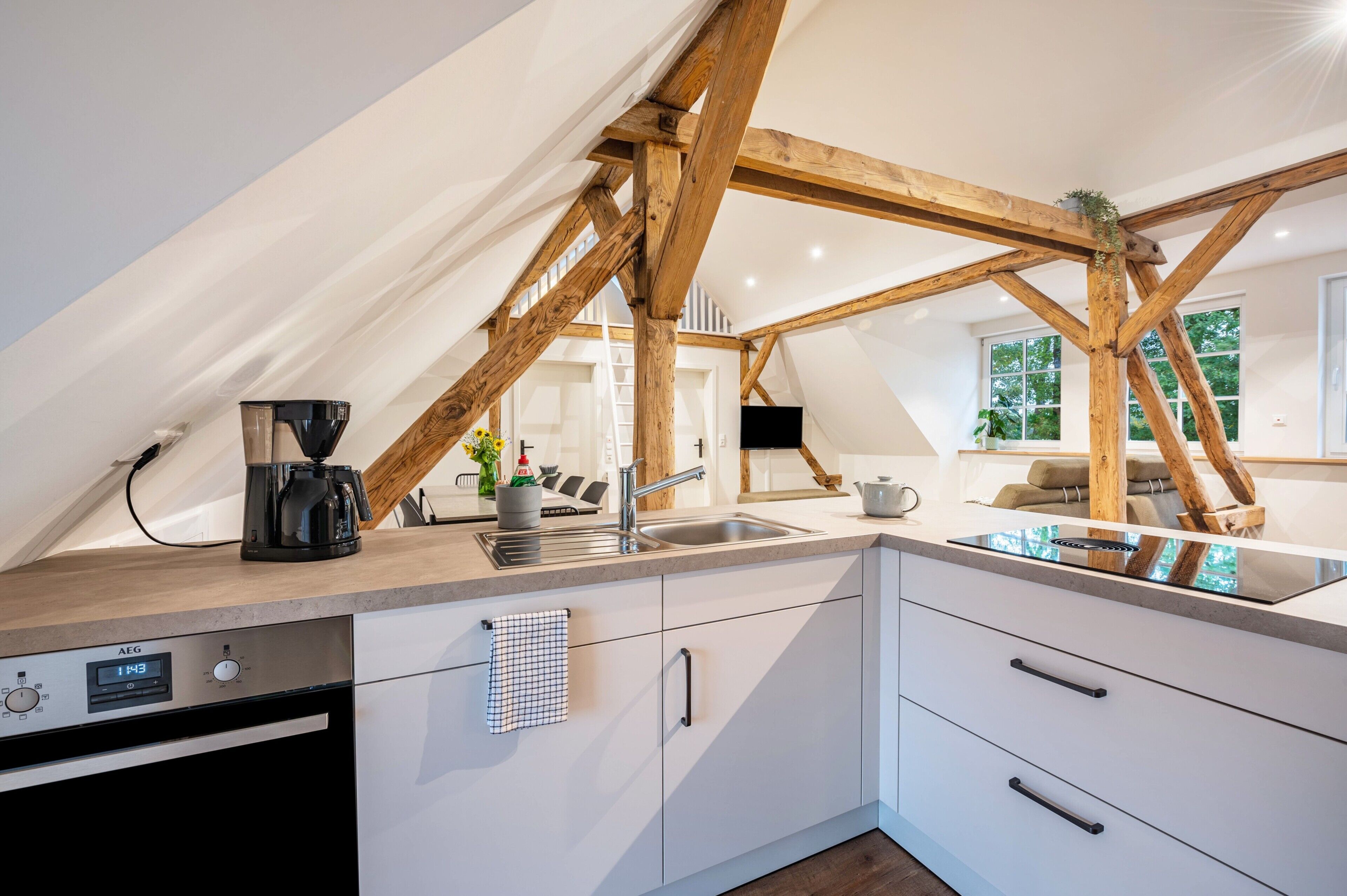 A modern kitchen with a built-in dishwasher, a coffee maker, and a sink.
