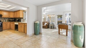 A spacious kitchen with wooden cabinets, a dishwasher, and a large window. - Coral Paradise Golf Course Pool Home | Close To The Beach | Palm Coast | Dog Friendly (Palm Coast)