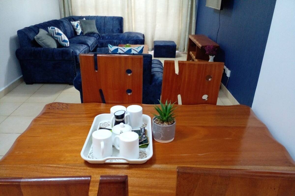 A dining table with a tray of white cups and a small potted plant.