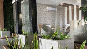 A modern lobby with a reception desk, seating area, and indoor plants. - Depa Exclusivo, Hermosa Vista, CON UNA Extraordinaria Ubicación (Boca del Río)