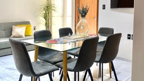 A modern dining area with a glass table, black chairs, and a decorative vase. - Depa Exclusivo, Hermosa Vista, CON UNA Extraordinaria Ubicación (Boca del Río)