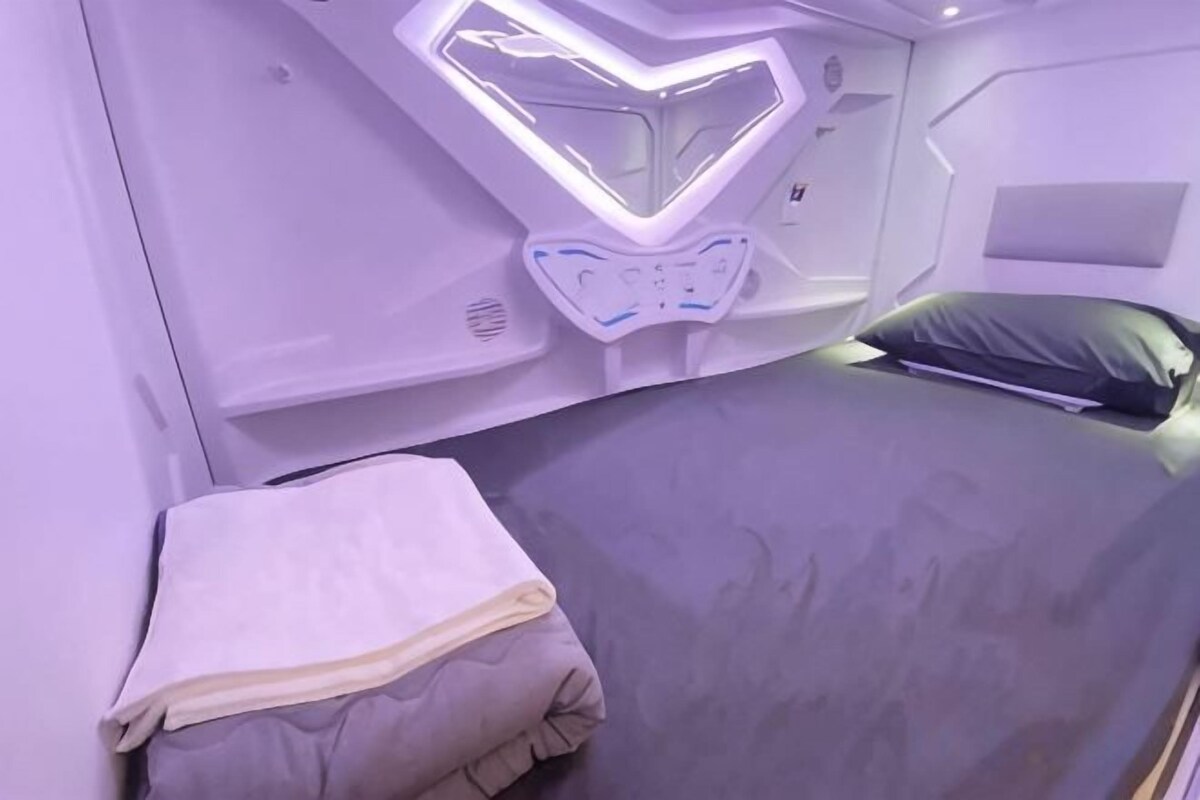 Een bed met hoofdbord, kussen en dekbed.