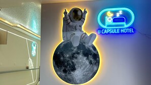 A neon sign with an astronaut and a moon, and a neon sign for "U Capsule Hotel". - U Capsule Hotel  (Kulai)