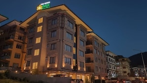A multi-story hotel with a prominent 'hotel' sign on the roof, multiple balconies, and a well-lit facade. - Hotel Dralha  (Thimphu)