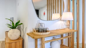 A wooden console table with a mirror, a lamp, and a tray with cups and a pitcher. - Vale dos Amores, a Home in Madeira (Calheta)