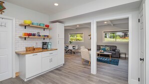A modern kitchen with white cabinets, wooden countertops, and colorful bowls on shelves. - Charming 3-bedroom house with spacious backyard in enjoyable Charlotte.  (Charlotte)