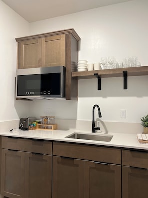 Enjoy cooking in this well-equipped kitchen with a microwave, sink, and ample countertop space.