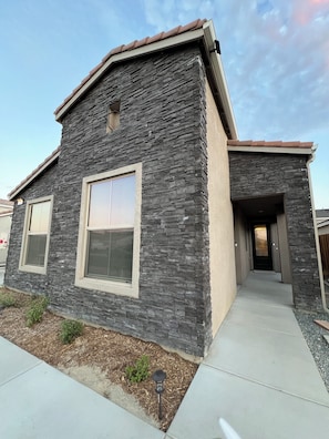 Situated on a well-maintained lawn, this building features a prominent entrance with a door and a small overhang.