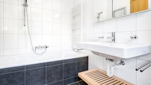 A modern bathroom with a bathtub, a sink, and a shower.