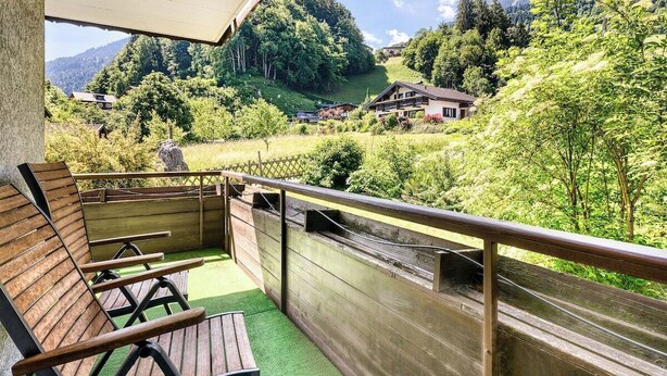 A balcony with wooden chairs and a view of a mountainous landscape. - Appartment Golm - Mäser-Apartments (Tschagguns)