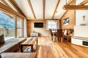 A wooden interior with a dining area, a sofa, and a fireplace. - Dahoam Appartments – 3-Room with balcony Zimba (Bürserberg)