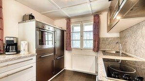 A modern kitchen with a built-in oven, a coffee machine, and a sink. - Chalet Mariedl (Tschagguns)