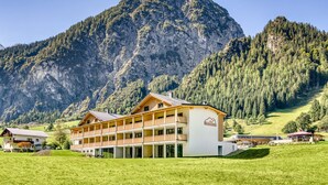 Ein Hotel mit zweistöckiger Bauweise, einem Balkon und Bergblick.