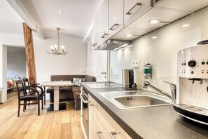 Enjoy cooking in this well-equipped kitchen with a central island, sink, and coffee machine.