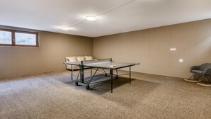 A room with a ping pong table, a sofa, and a rocking chair. - Alpenblick Appartements - Studio (Schruns)