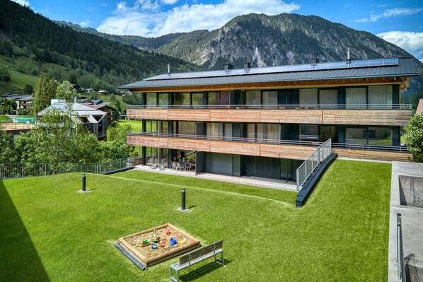 A modern building with a flat roof, large windows, and a wooden facade.