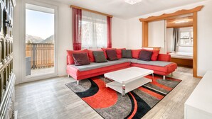 Een moderne woonkamer met een hoekbank, een witte salontafel en uitzicht op het buitengebied.