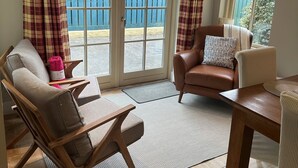 A cozy room with a brown leather armchair, a wooden chair, and a small table. - 7 Oakwood Manor Kenmare (Kenmare)