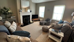 A living room with a fireplace, a sofa, a bean bag, and a TV. - 7 Oakwood Manor Kenmare (Kenmare)