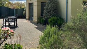 A patio with a table and chairs, a small tree, and various plants. - 7 Oakwood Manor Kenmare (Kenmare)