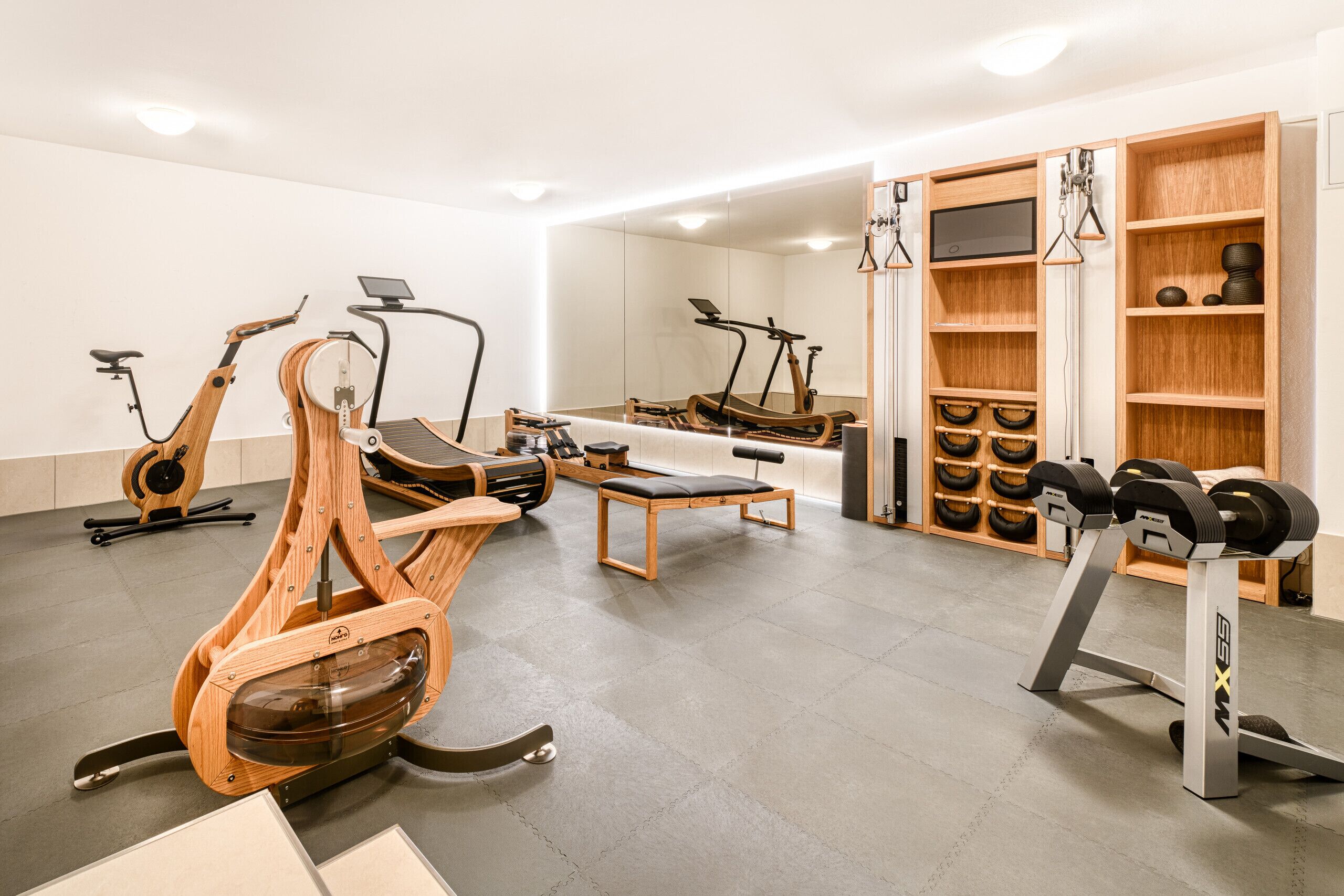 Une salle de sport moderne équipée de divers appareils d’exercice, notamment des tapis de course, des vélos d’appartement et des appareils de musculation.