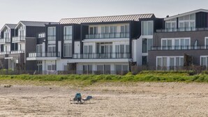 Um edifício residencial moderno, de vários andares, com varandas e grandes janelas.