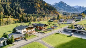 A residential area with houses, a road, and a mountain backdrop. - Holiday apartment Aurora (St. Gallenkirch)