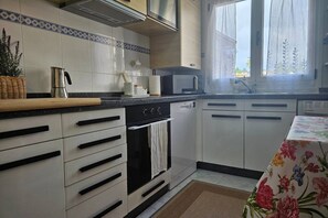 Une cuisine moderne avec des armoires blanches, une cuisinière en acier inoxydable et un four à micro-ondes.