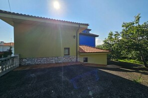 Un bâtiment avec des fondations en pierre, un mur jaune et une partie supérieure bleue.